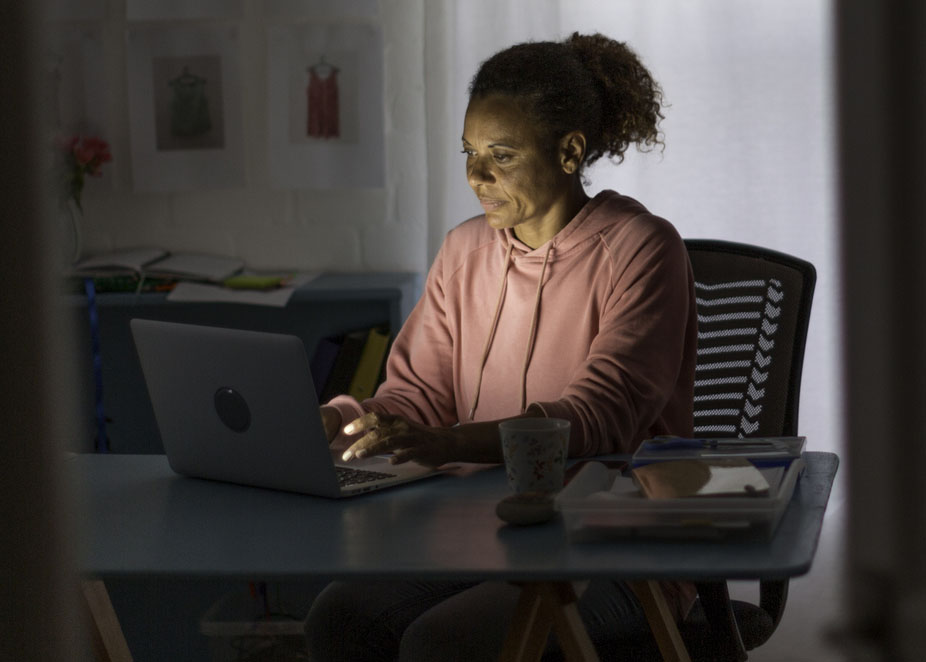 Mature woman working from home on a video call in the evening